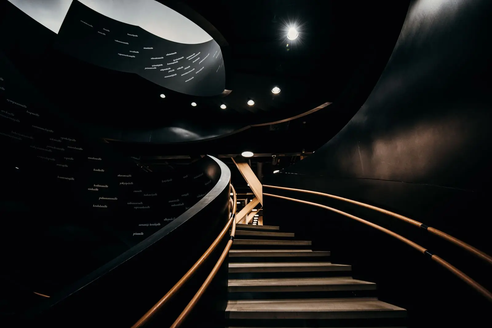 A dark spiral stair under a single key light